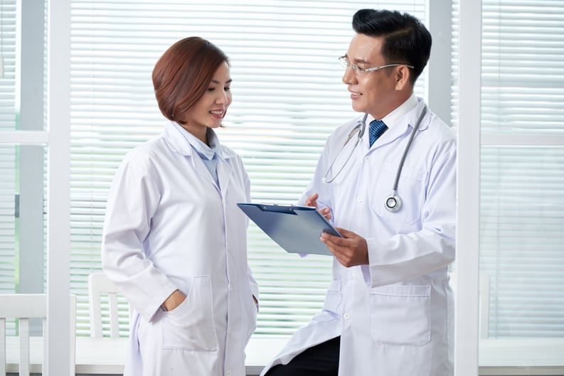 two-medical-colleagues-discussing-agenda-briefing two-medical-colleagues-discussing-agenda-briefing